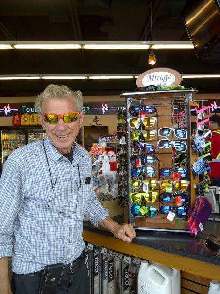 President of Mirage standing next to sunglass stand in store